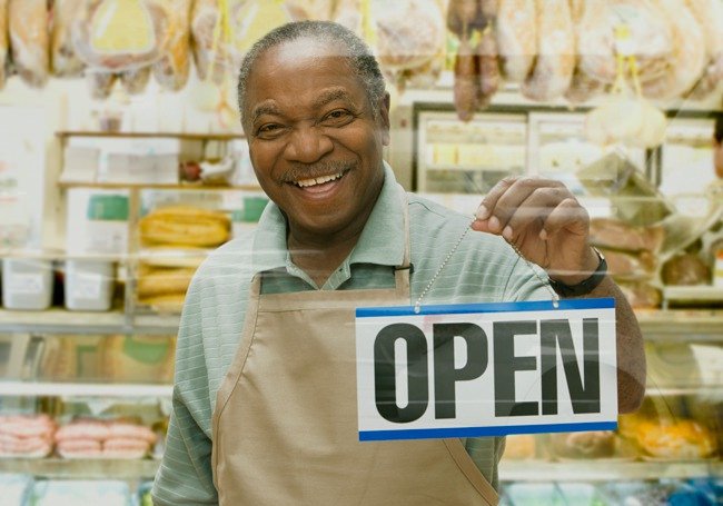 man holding a business open sign