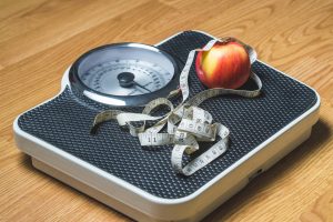 Weight Loss Weighing scale and an apple and a tape measure